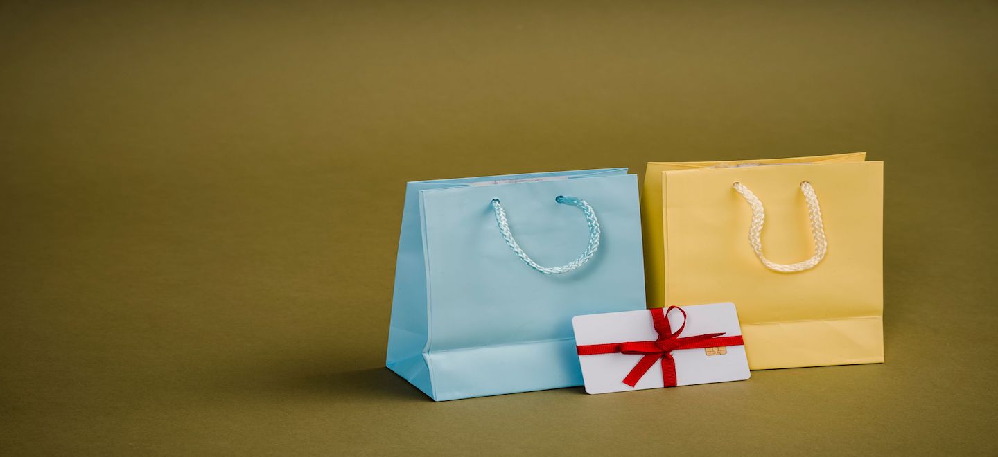 青と黄の紙袋とリボンで結ばれた封筒