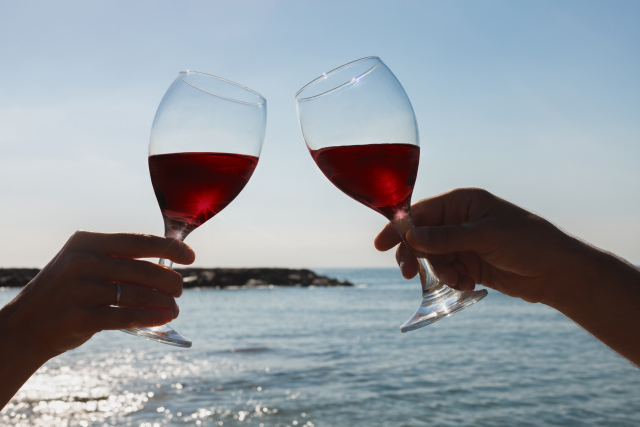 海を背景にワインで乾杯している様子